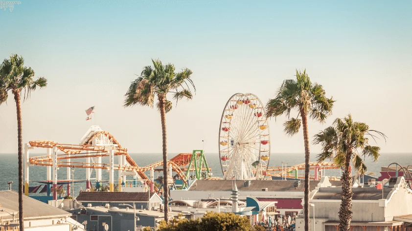 The Versatile Applications of RFID in Entertainment A scenic view of an outdoor amusement park with a Ferris wheel and coastal roller coaster under bright sunlight