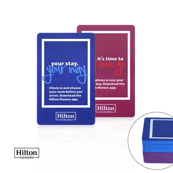 Two customized dual-colored digital key promotional cards alongside stacked edge-colored hotel credentials