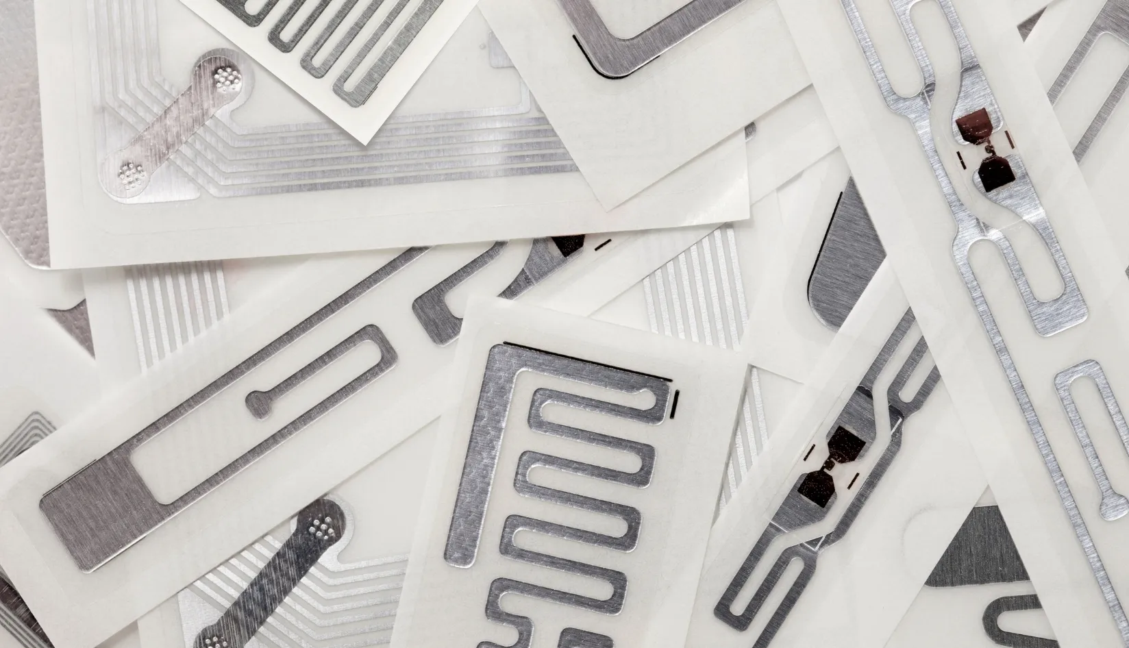 Types of RFID Inlays Explained Wet vs. Dry, HF vs. UHF — Which Is Right for You Different types of RFID inlays displayed on a table, showing wet and dry inlays in both HF and UHF formats used for various tagging applications