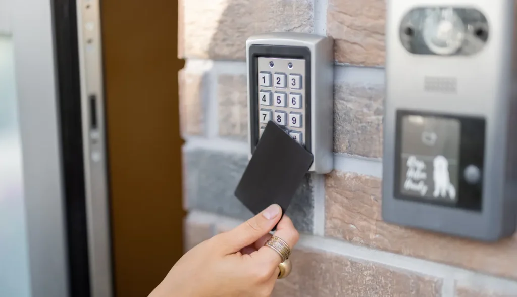 Hand tapping an NFC card on a keypad access reader, showing NXP NFC chip use in ID and credential systems.