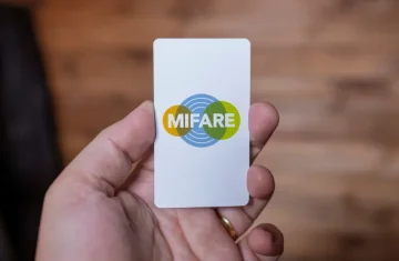 MIFARE Plus SE vs. EV2 What’s the Difference and Which One Is Right for You Hand holding a white MIFARE card with the MIFARE logo.