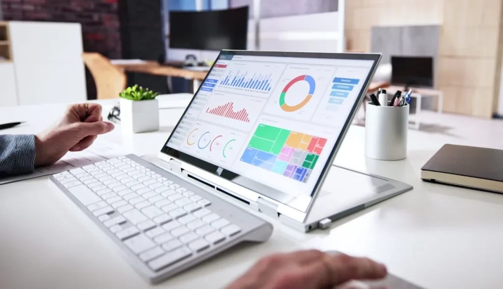 Laptop displaying data analytics charts in a modern office workspace.