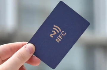 Hand holding a standard NFC card marked with the NFC logo, representing low-security NTAG/UID card types.