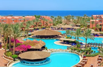How Resort RFID Cards Are Transforming the Guest Experience A luxurious beachfront resort with multiple swimming pools, palm trees, and red-brick buildings, showcasing a modern vacation destination.