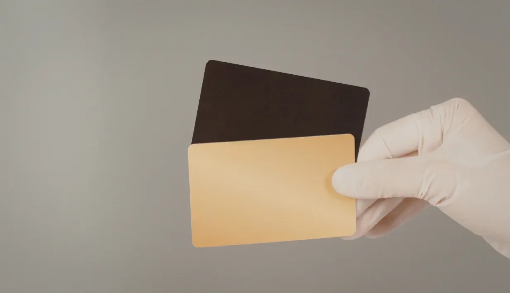 Gloved hand holding blank NFC cards, representing easily cloneable unsecure NFC card types.