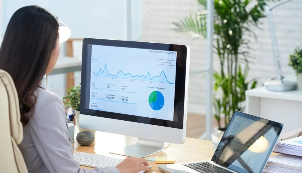 Hotel IT analyst reviewing visitor activity statistics on a computer dashboard.