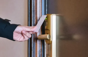 RFID Security Risks in Hotels What Most Properties Overlook Guest using RFID hotel key card to unlock electronic door lock.