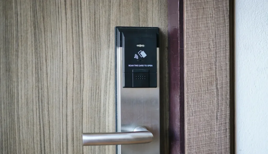 RFID card reader on wooden door lock with 'Scan the card to open' instruction.