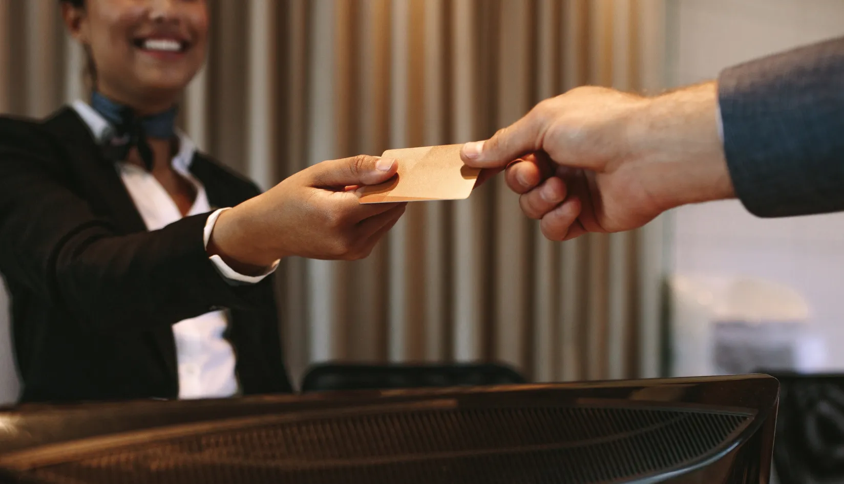 Who Still Prefers Physical Hotel Card Keys Hotel staff handing a hotel card key to a guest at check in.
